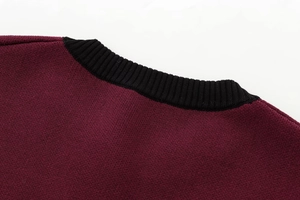 Detail of the crew neck collar featuring burgundy knit fabric and black ribbed trim