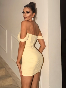 Detail of yellow bodycon dress showing ruched fabric texture and slim fit back design