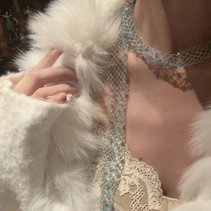 Elegant silver mesh necklace featuring light blue crystals on a white fur background