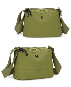 Détail de deux sacs à bandoulière en nylon vert avec fermetures éclair et trèfle en métal