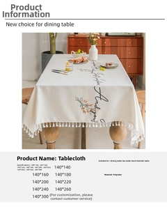 Detail of hollow embroidered tablecloth featuring delicate floral patterns and white tassels
