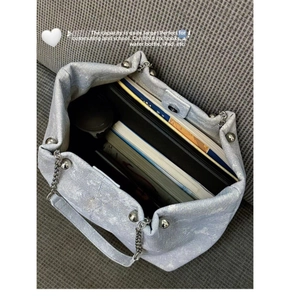 Top view of large capacity light blue denim tote bag filled with books and an iPad