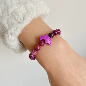 Detail of purple marble stone beaded bracelet featuring a cute dolphin charm