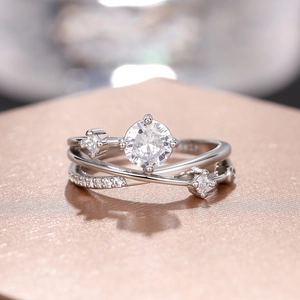Macro-detail van zilveren ring met kruislingse band en sprankelende zirkonia-stenen