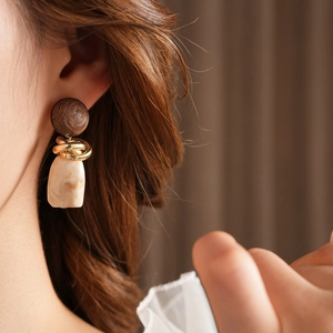 Detail of vintage geometric wood and resin earrings on model with marble drop