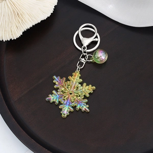 Macro view of iridescent acrylic snowflake keychain with silver lobster clasp and colorful bead