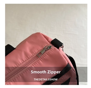 Detail showing smooth silver metal zipper and durable mesh side pocket on pink travel bag