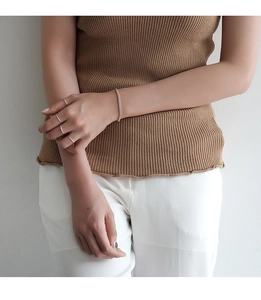 Detail shot of a model wearing minimalist S925 silver slim rings and a matching chain bracelet