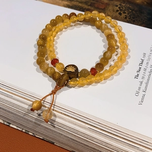 Close-up of double-loop beaded bracelet with amber yellow beads and lotus wood decor