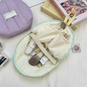Detailed interior of quilted shell cosmetic bag showing compartments and elastic straps
