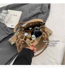 Top view of large capacity khaki leather bucket bag with magnetic clasp and woven strap