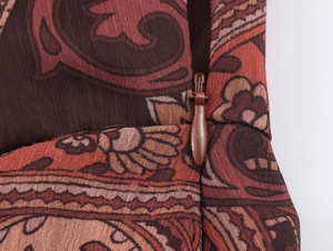 Close-up of invisible zipper and paisley print detail on a bohemian chiffon maxi dress