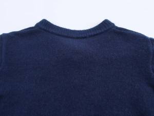 Close-up of navy blue knit cardigan featuring a ribbed crew neck and soft wool texture