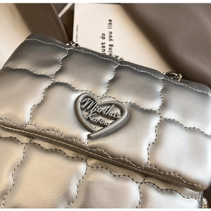 Macro shot of silver quilted bag with Martha Karina heart-shaped metal buckle detail