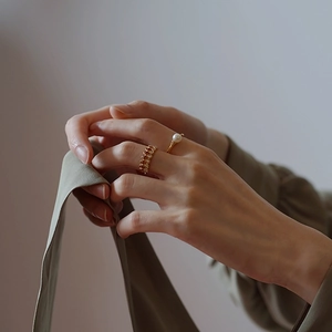 Detail of 14k gold plated sterling silver pearl ring worn with a diamond hollow ring