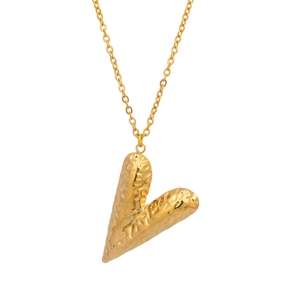 Détail du collier cœur doré avec texture métallique martelée et finition brillante sur blanc