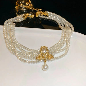 Vue détaillée du collier de perles multicouches avec un pendentif abeille doré