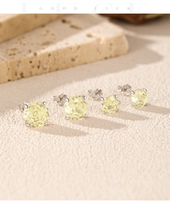 Macro shot of S925 silver stud earrings featuring faceted yellow octagon-cut crystals