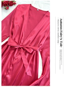 Détail du peignoir en satin rouge rose avec texture de soie et taille ceinturée