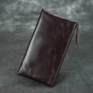Detailed view of dark brown crazy horse leather wallet with fine stitching and metal zipper