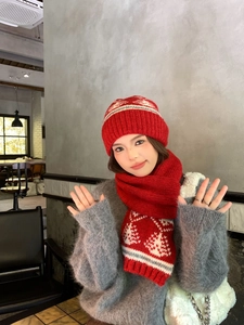 Dettaglio del set cappello e sciarpa in maglia rossa spessa con motivi Fair Isle invernali