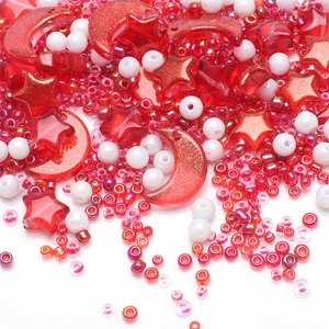 Close-up of red and white DIY craft beads with star and moon shapes for jewelry making