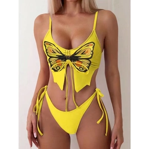 Yellow two-piece bikini with butterfly print and lace-up top on a model, sexy swim set