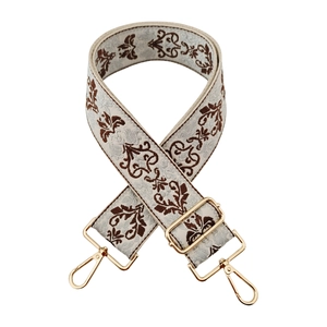 Detail of vintage floral jacquard wide strap with golden metal lobster clasps
