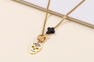 Detail of gold skull and black cross pendant necklace with OT toggle clasp design