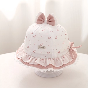 Detail eines rosa Sonnenhuts für Babys mit Herzmuster, Schleife und Spitzenkante