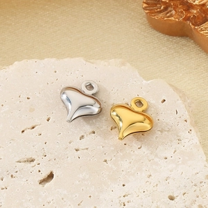 Dettaglio di pendenti a cuore in oro e argento in acciaio inossidabile lucido su pietra