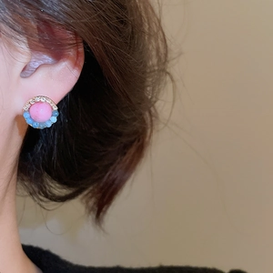 Detail showing handcrafted flower earring with pink bead, blue accents and crystals