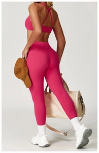 Detail of high-waist yoga pants and cross-strap sports bra in magenta for fitness