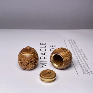 Detailed view of hand-carved green sandalwood diffuser pendant with intricate floral patterns