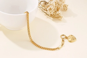 Detail of gold titanium heart necklace and bracelet set with paperclip chain
