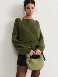 Olive green knit sweater and black leather mini skirt outfit with woven handbag