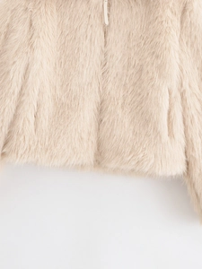 Detailed close-up of beige faux fur coat featuring fluffy texture and zipper closure