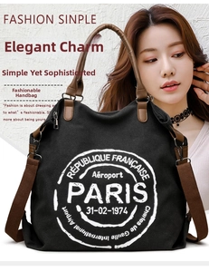 Close-up of black canvas tote bag with Paris theme print and brown shoulder strap