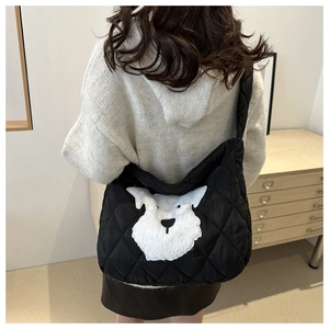 Detail of black quilted tote bag featuring a cute white schnauzer embroidery on nylon fabric