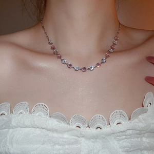 Close-up of elegant silver necklace with pink and white round gemstones on a model's neck