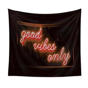 Detail of Good Vibes Only neon lettering on a black bohemian tapestry backdrop