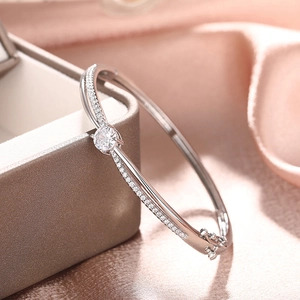 Close-up of silver crossover bracelet with round zircon on a premium gift box