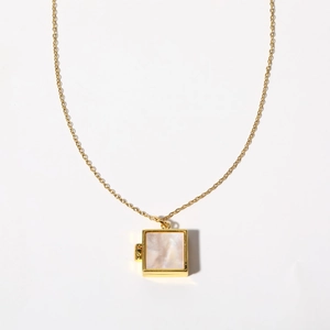 Detailed view of square gold locket necklace with iridescent white mother of pearl inlay