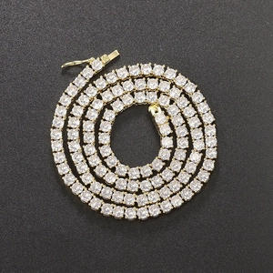 Close-up of gold-plated tennis chain with round-cut zircons on black background