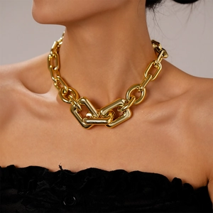 Macro shot of bold gold-tone metallic interlocking chunky chain link necklace on model