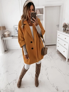 Gros plan détaillé du manteau en laine jaune moutarde avec boutons noirs et revers