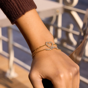 Détail d'un bracelet double couche plaqué or 18K avec cœur scintillant et zircons