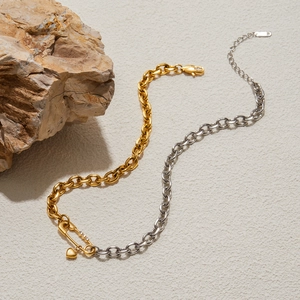 Detailed shot of mixed-tone paperclip chain necklace with a crystal heart pendant
