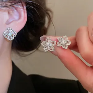 Elegante Blumen-Ohrstecker aus Silber mit Perlen und Zirkonia am Modell getragen