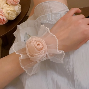 Détail d'un bracelet rose en satin rose tendre avec dentelle et maille blanche
